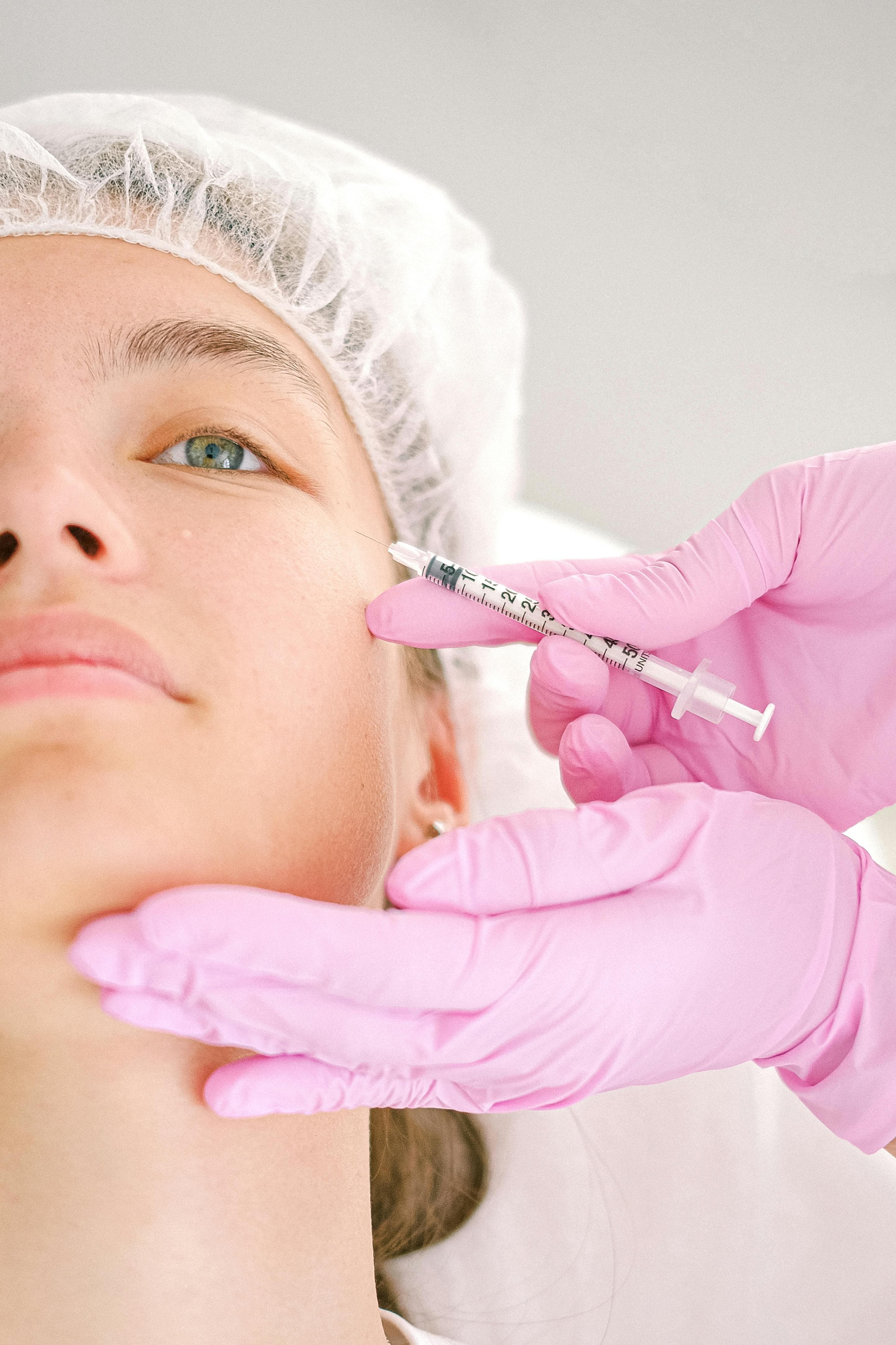 Provider administering a facial aesthetic treatment to a client